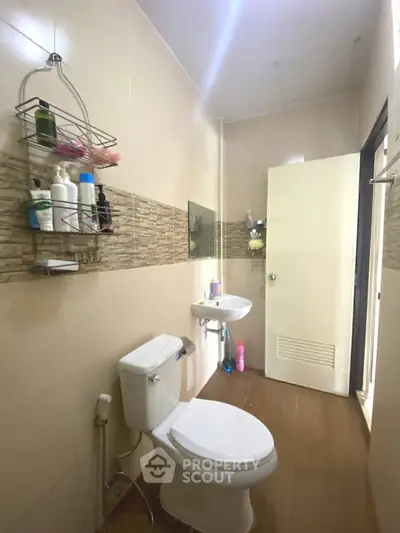 Modern bathroom with sleek fixtures and stylish tile accents, featuring a toilet and sink.