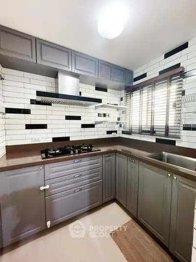 Modern kitchen with sleek cabinetry and gas stove in stylish apartment.