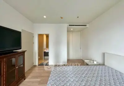 Spacious bedroom with modern decor and ensuite bathroom in a stylish apartment.