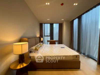 Luxurious bedroom with modern decor and large windows offering city views, perfect for urban living.