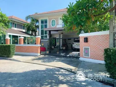 Charming two-story house with gated entrance and lush greenery in a serene neighborhood.