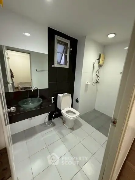 Modern bathroom with sleek fixtures and glass basin in a contemporary home.