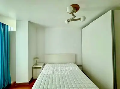 Modern minimalist bedroom with white decor and blue curtains