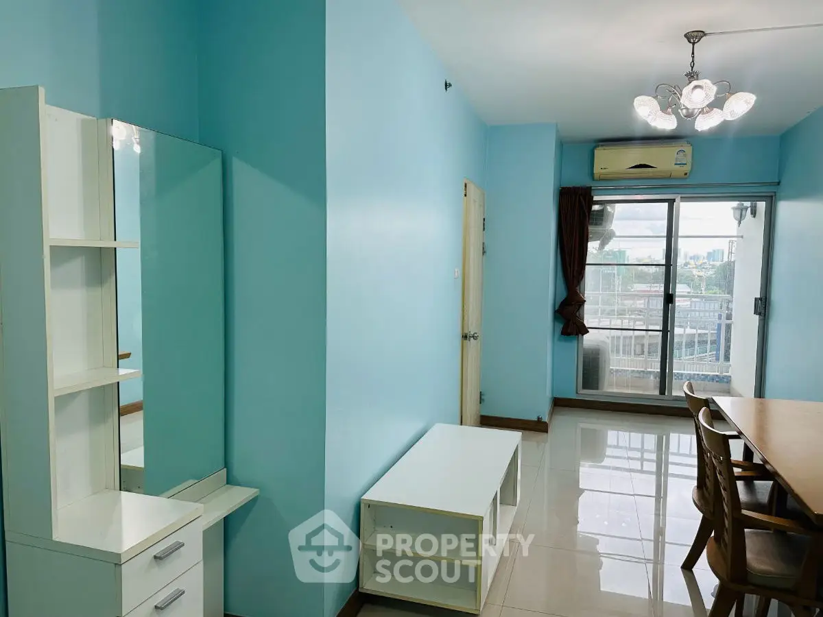 Bright living room with blue walls, modern furniture, and balcony access.