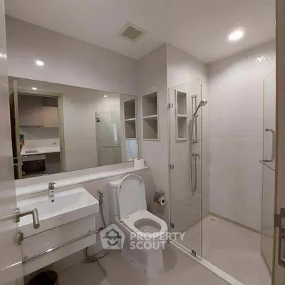 Modern bathroom with glass shower and sleek fixtures in a contemporary home.