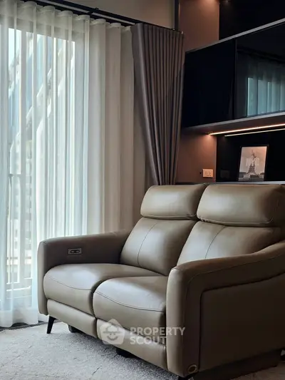 Modern living room with elegant leather sofa and floor-to-ceiling window drapes.