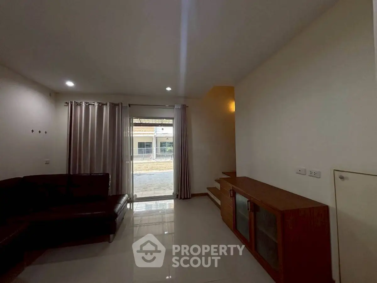 Spacious living room with modern furniture and large window for natural light.