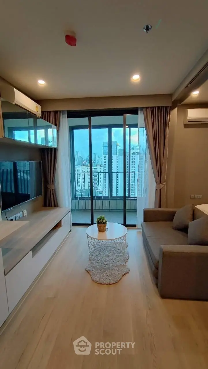 Modern living room with city view, featuring sleek furniture and large windows for natural light.