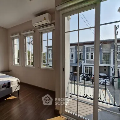 Spacious bedroom with balcony and street view in modern townhouse