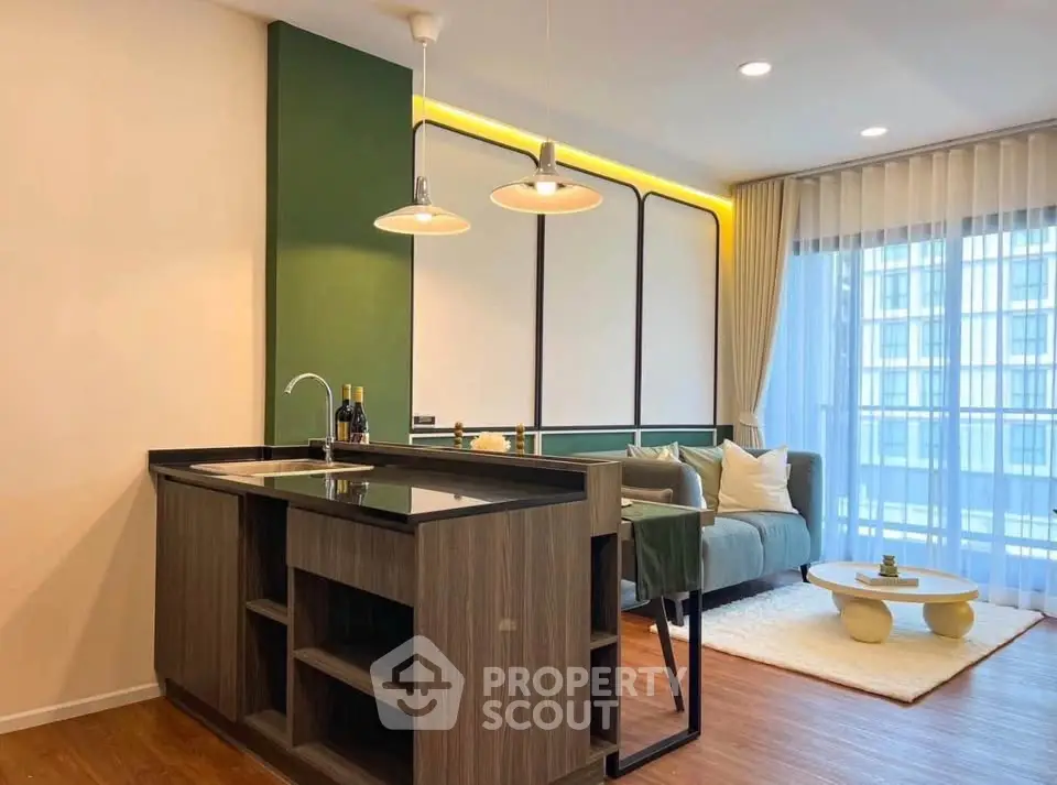 Modern living room with stylish open kitchen and large windows in a contemporary apartment.
