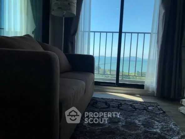 Cozy living room with stunning ocean view from balcony, perfect for relaxation.