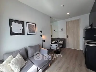 Modern living room with stylish decor and compact dining area in a cozy apartment.