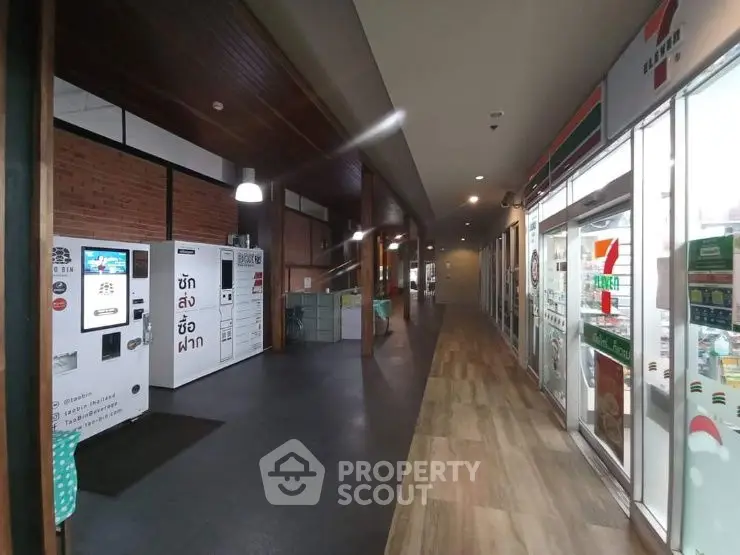Modern commercial corridor with retail shops and vending machines