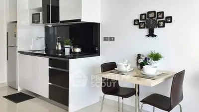 Modern kitchen with sleek black and white design, dining area, and stylish decor.