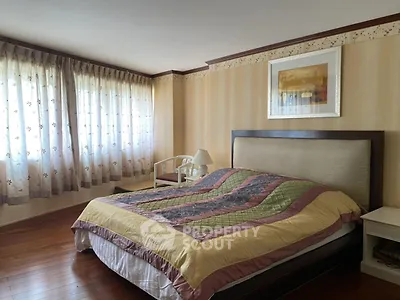 Spacious bedroom with elegant decor and large windows for natural light