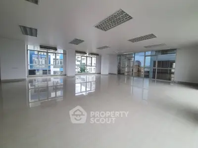 Spacious modern office space with large windows and ample natural light.