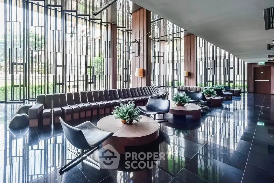 Luxurious modern lobby with sleek seating and floor-to-ceiling windows offering lush garden views.