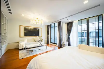 Luxurious bedroom with elegant chandelier and large windows offering stunning views.