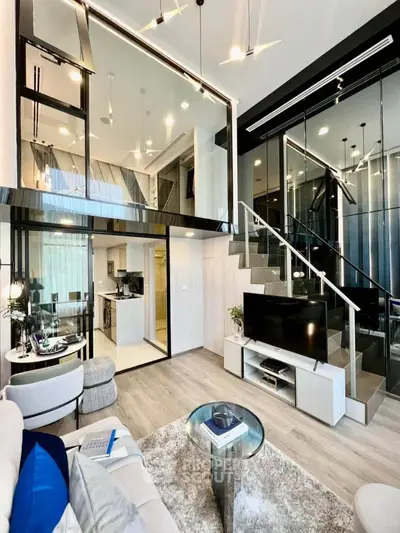 Luxurious duplex apartment with high ceilings, modern glass staircase, and sleek kitchen design, perfect for upscale urban living.