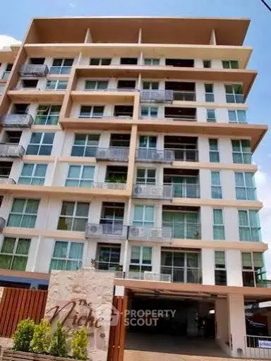Modern multi-story apartment building with large windows and balconies, ideal for urban living.
