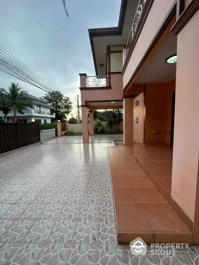 Spacious driveway and entrance of a modern two-story home with tiled flooring.