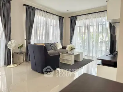Elegant living room with modern decor, large windows, and stylish furniture, perfect for relaxation and entertaining.