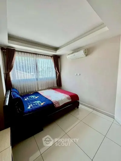 Cozy bedroom with large window and air conditioning, perfect for relaxation.