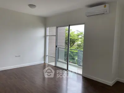 Spacious modern living room with hardwood floors and balcony view