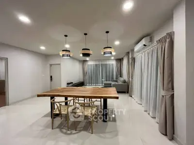 Spacious modern living room with elegant lighting and stylish dining area.