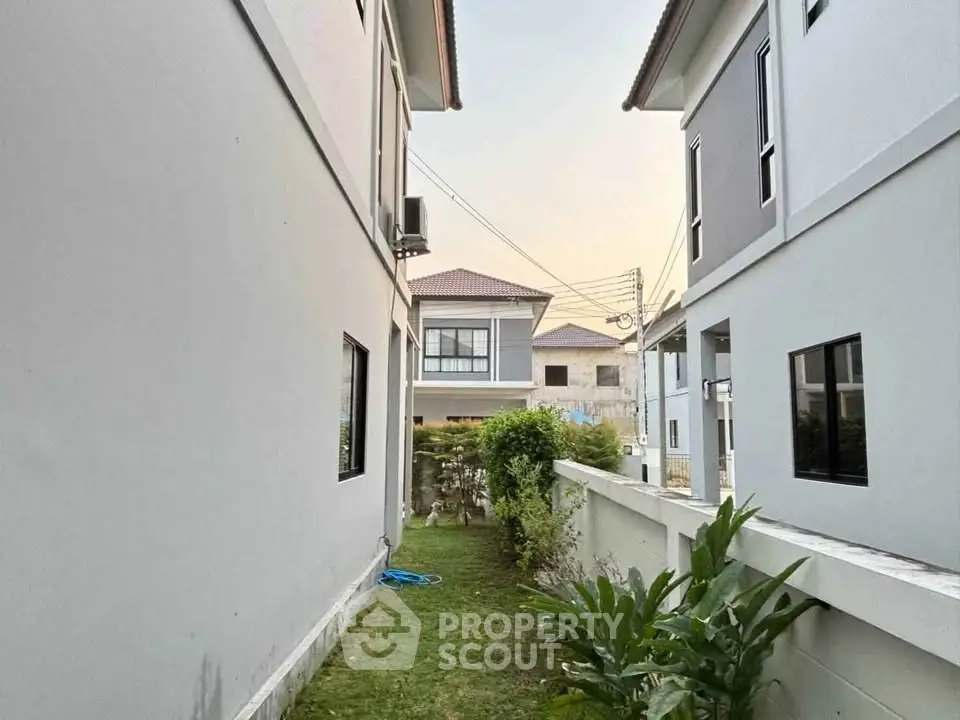Modern residential buildings with lush garden and clear sky view.