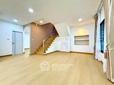 Spacious modern living room with wooden flooring and elegant staircase