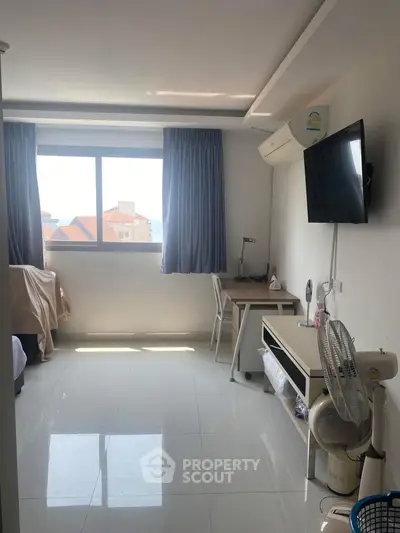 Bright and airy bedroom with modern furnishings and large window view.