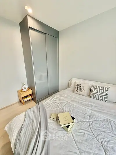 Modern bedroom with sleek wardrobe and cozy bedding in minimalist design.
