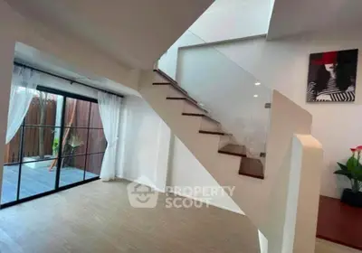Modern interior with stylish staircase and glass doors leading to patio
