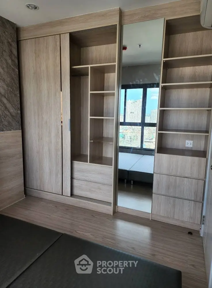 Modern bedroom with built-in wooden wardrobe and city view window