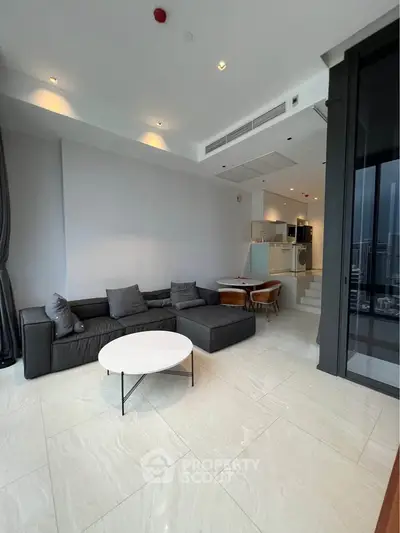 Spacious modern living room with sleek design and open layout, featuring a cozy seating area and dining space.