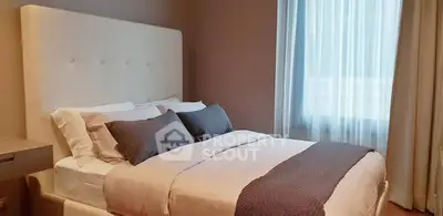 Elegant bedroom with plush bed and soft lighting, perfect for relaxation.