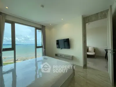 Stunning beachfront bedroom with panoramic ocean views and modern decor.