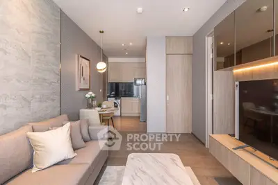Modern living room with open kitchen, stylish decor, and cozy ambiance in a contemporary apartment.