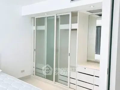 Modern bedroom with sleek built-in wardrobe and minimalist design.