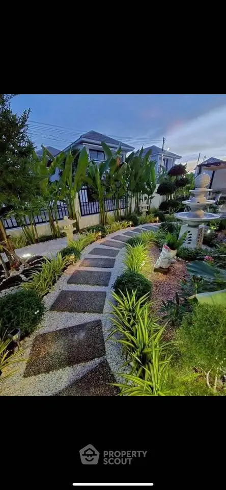 Beautifully landscaped garden with pathway and lush greenery in a residential setting.