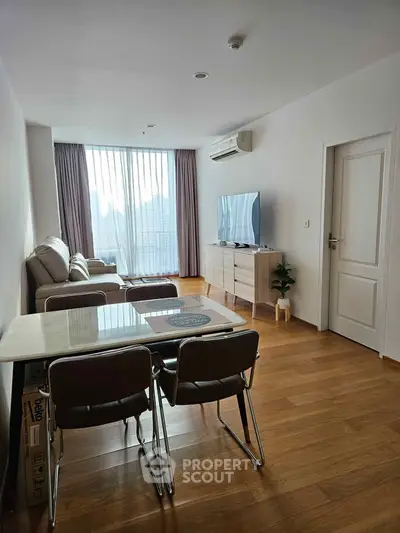 Spacious living room with modern furniture and large window offering natural light.