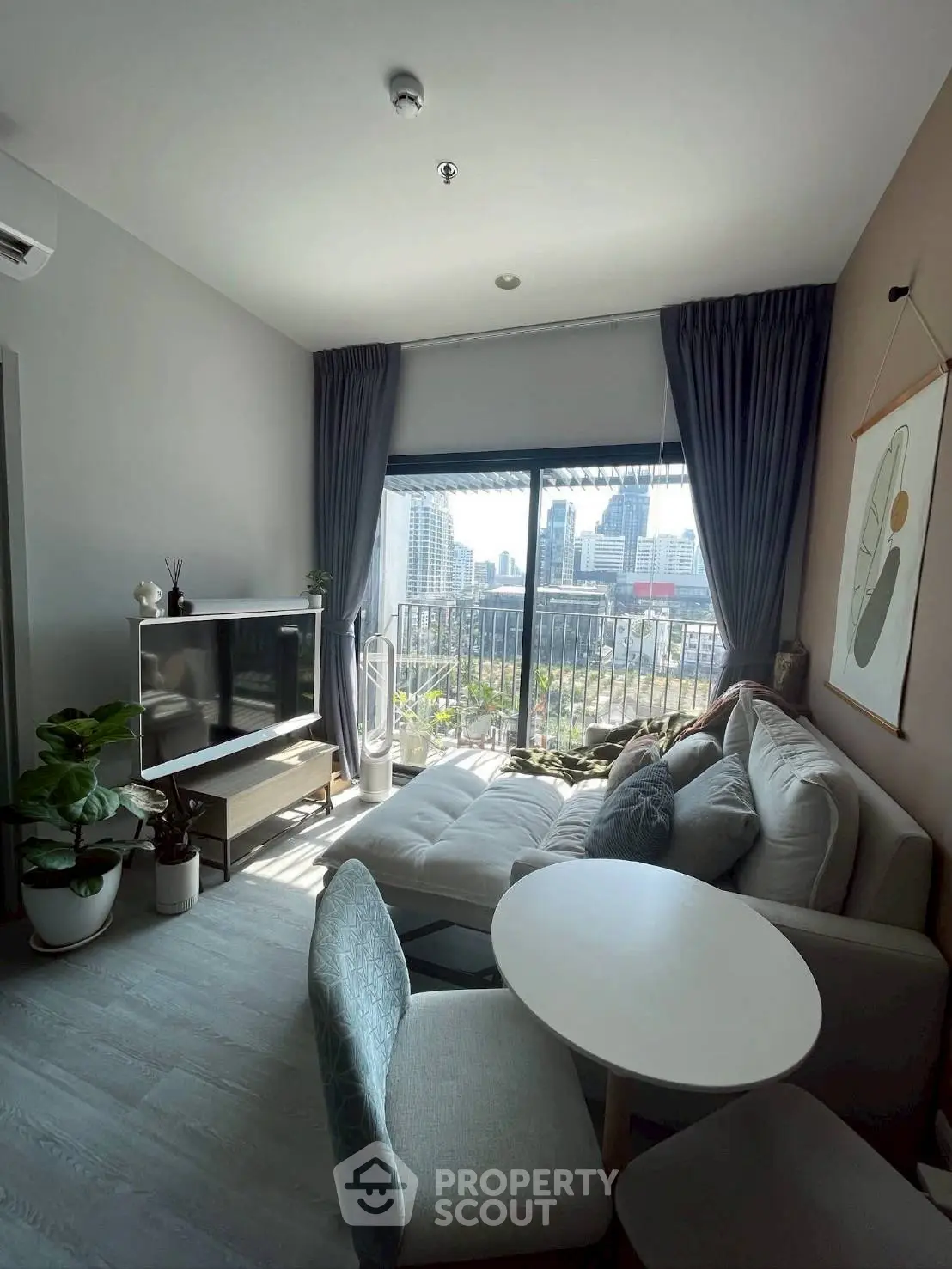 Modern living room with city view, stylish decor, and cozy seating area.