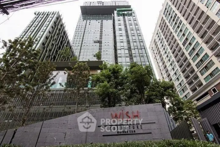 Modern high-rise building with lush greenery and sleek architectural design.