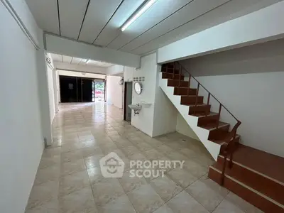 Spacious open-plan interior with tiled flooring and staircase, ideal for versatile use.