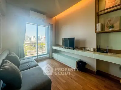 Modern living room with city view, featuring sleek furniture and natural light.