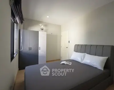 Modern bedroom with sleek design and ample natural light, featuring a comfortable bed and stylish wardrobe.