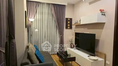 Cozy living room with modern decor and large TV, perfect for relaxation.