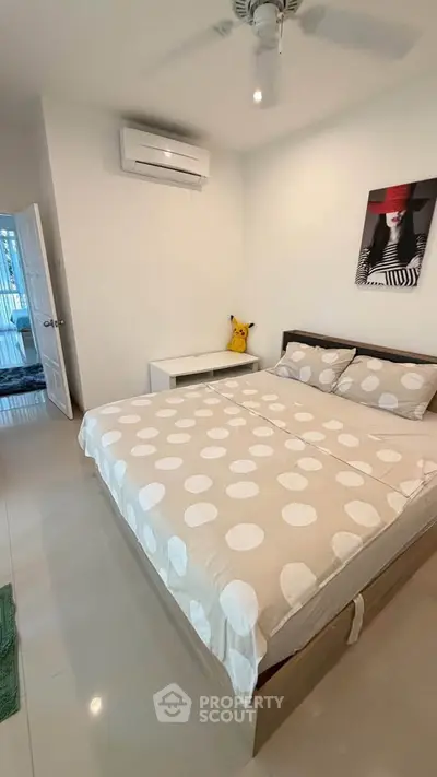 Cozy bedroom with modern decor and air conditioning in a stylish apartment.