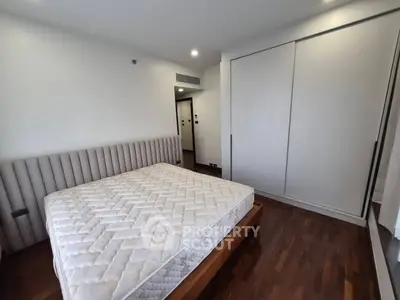 Spacious bedroom with modern design and ample storage in a luxury apartment.